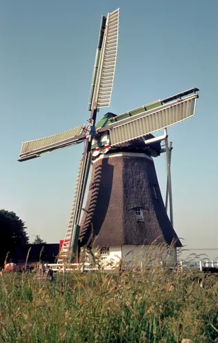 Gescande staande dia van een windmolen in een weiland